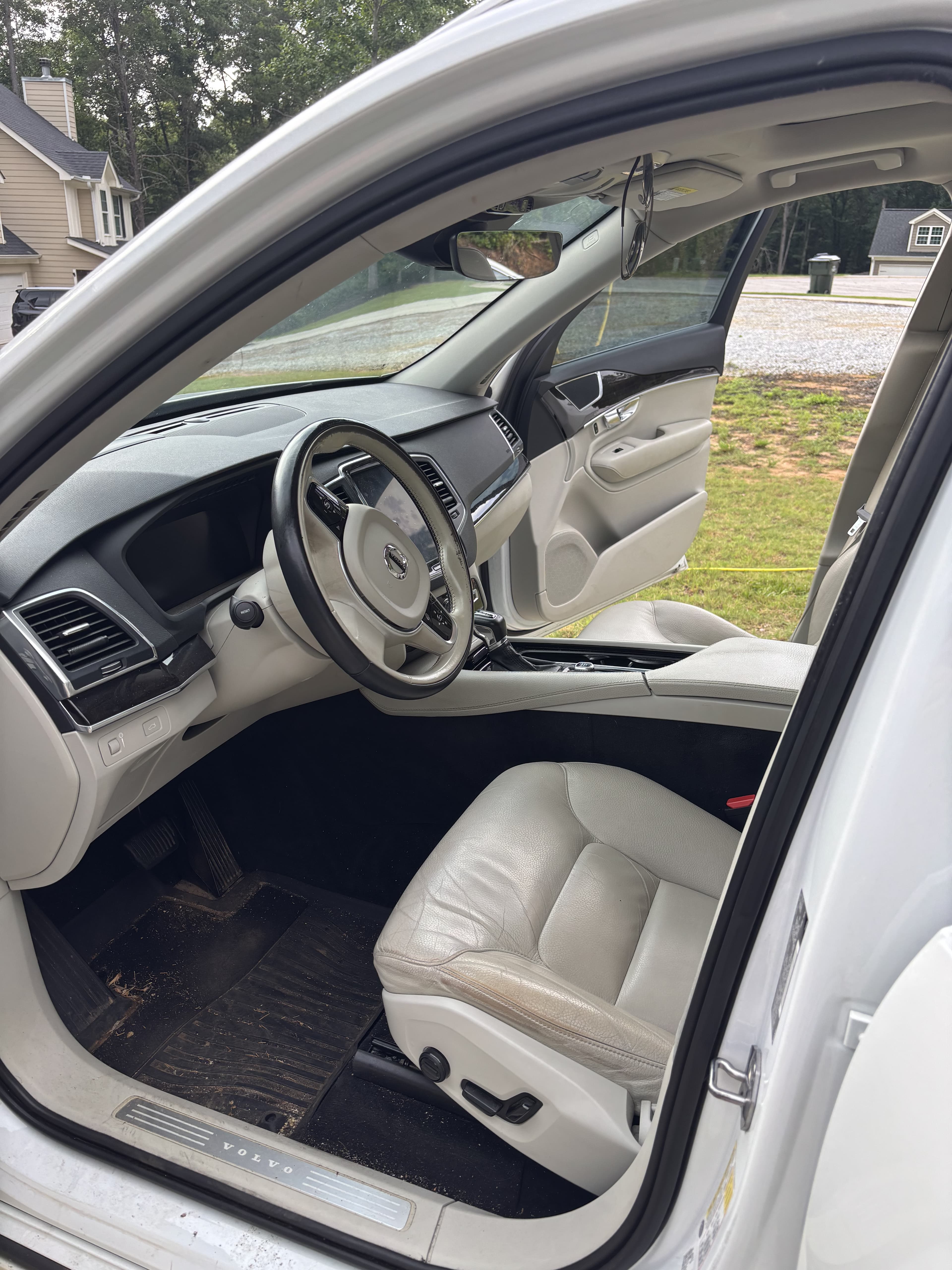Interior view of a white Volvo featuring light gray leather seats and a black dashboard.